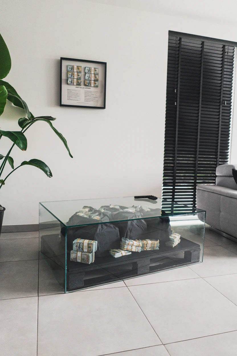 Glass coffee table with money on it in a living room setting